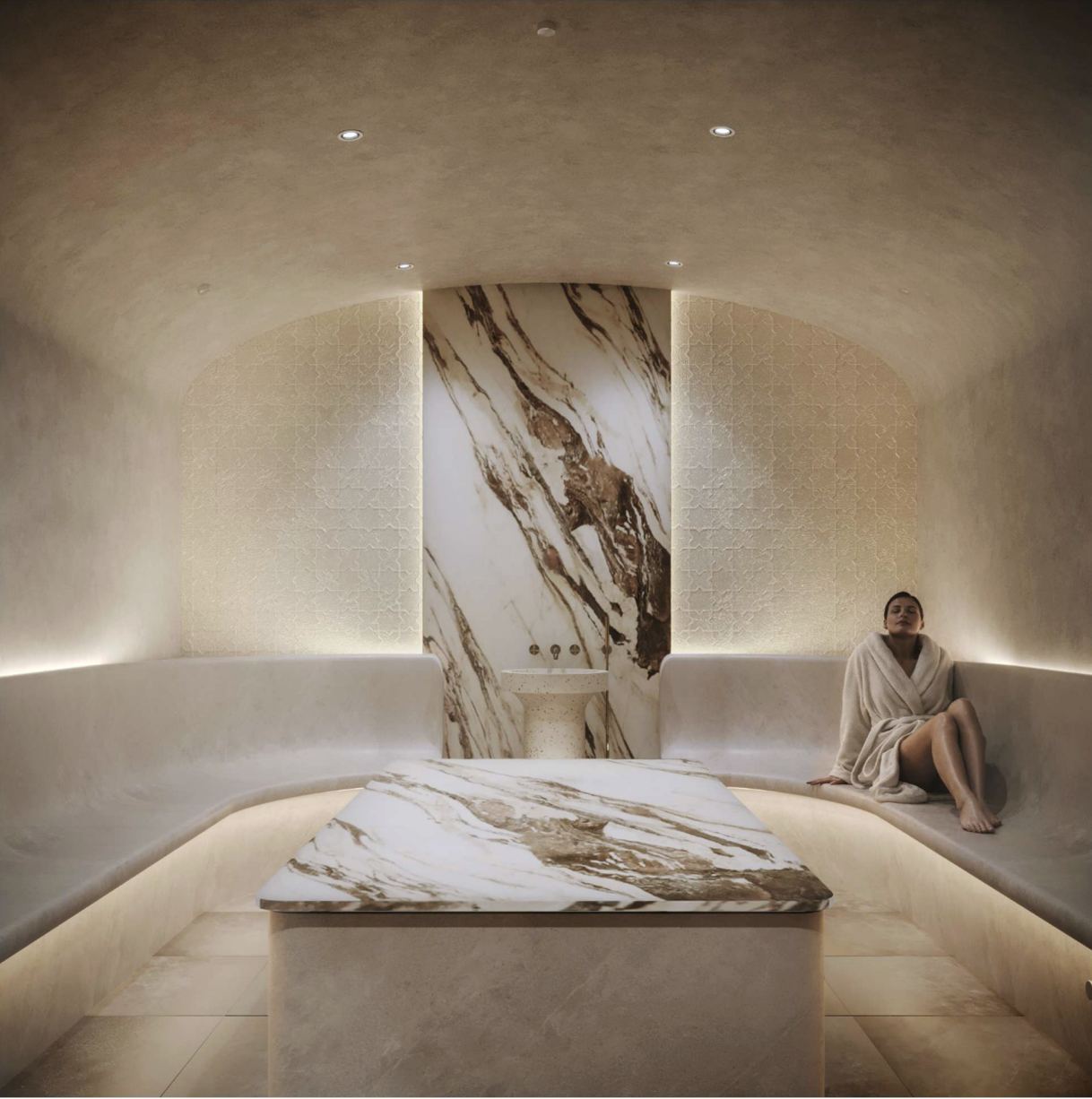 The hammam: a marble slab beneath a lit stone wall